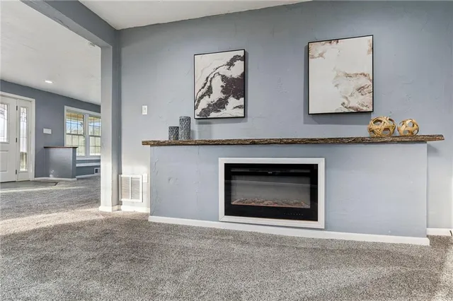an empty room with a fireplace and cabinet