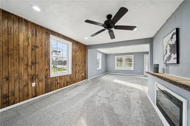 a view of an empty room with a window and a kitchen