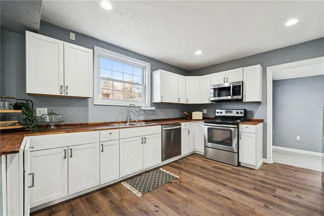 a kitchen with granite countertop white cabinets and appliances