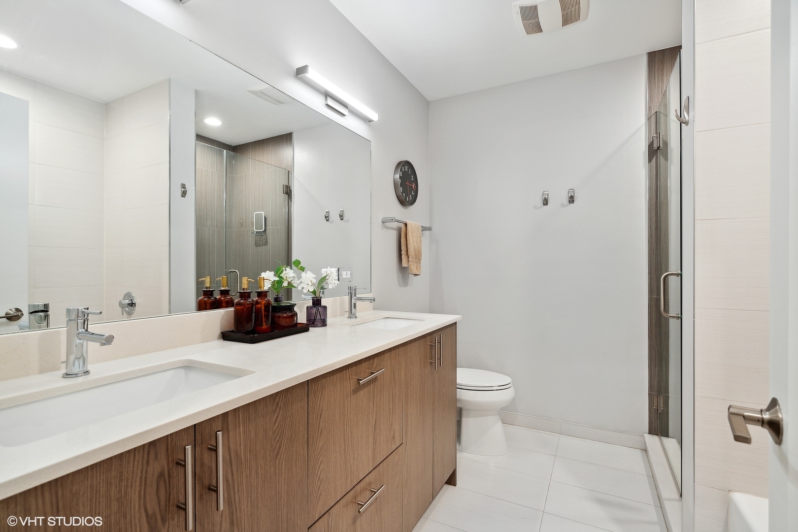 1044 West Polk Street, Unit 1 Chicago, IL 60607 - Photo 12 of 22 a bathroom with a double vanity sink toilet and a mirror