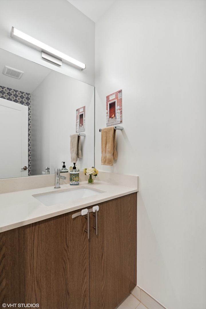 1044 West Polk Street, Unit 1 Chicago, IL 60607 - Photo 10 of 22 a bathroom with a sink and a mirror