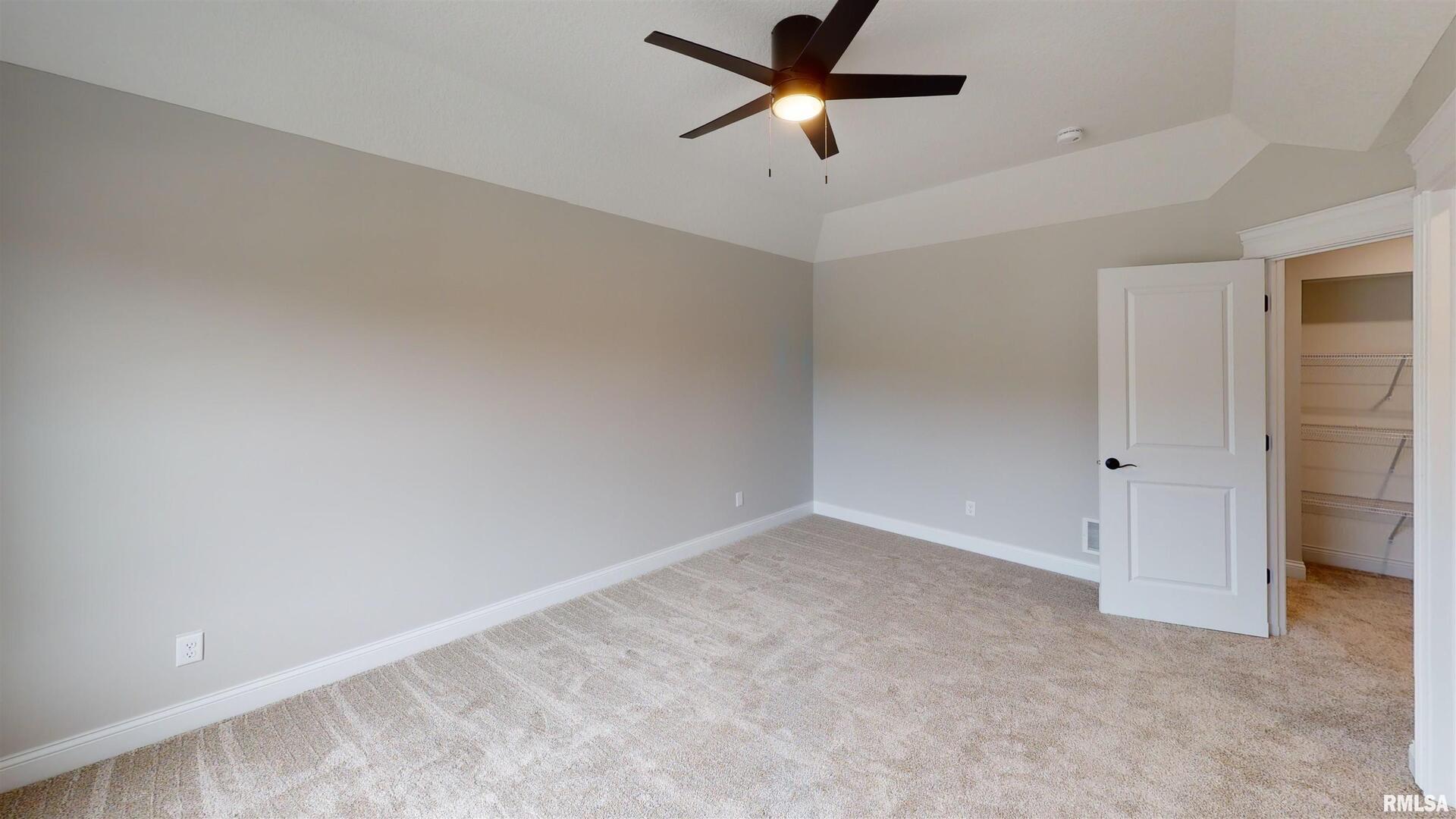 11 Faiths Way Bettendorf, IA 52722 - Photo 11 of 22 an empty room with a ceiling fan and carpet