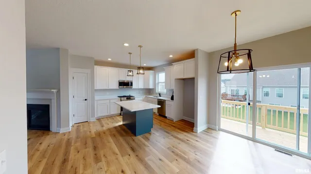 a open kitchen with stainless steel appliances granite countertop a refrigerator a sink dishwasher and a stove with wooden floor