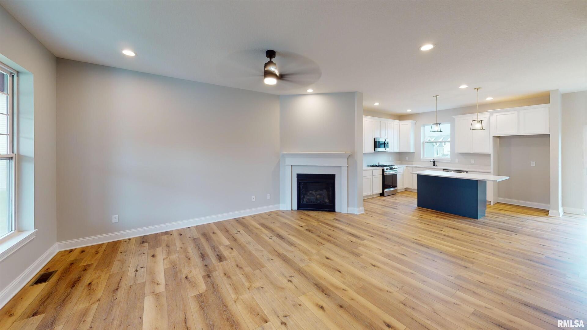 11 Faiths Way Bettendorf, IA 52722 - Photo 2 of 22 a view of kitchen with kitchen island microwave and wooden floor