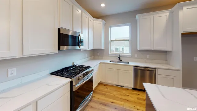a kitchen with stainless steel appliances white cabinets and sink