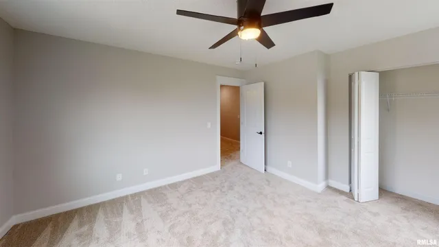 an empty room with a ceiling fan and a window