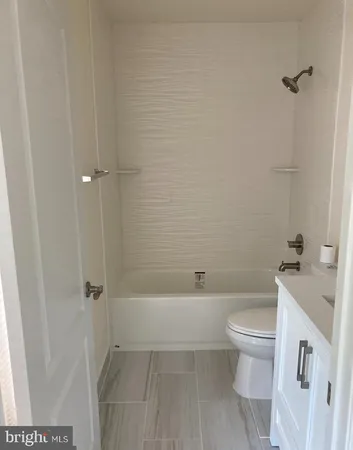 a white toilet sitting next to a bath tub