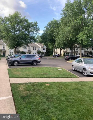 a front view of a house with a garden and trees