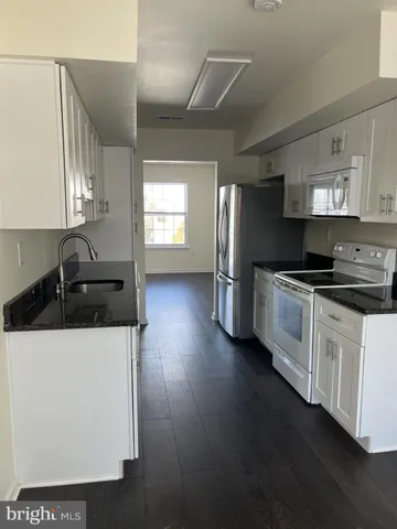 a kitchen with stainless steel appliances a sink a stove a refrigerator and cabinets