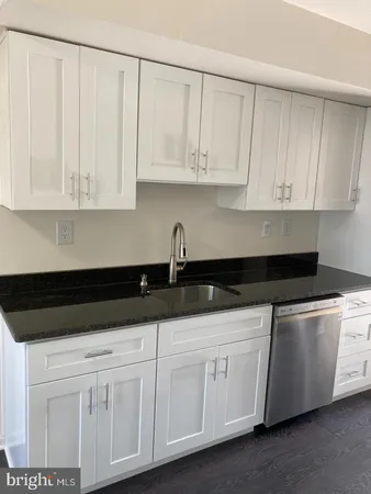 a kitchen with white cabinets and a sink