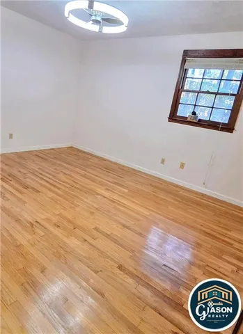 a view of a room with wooden floor and a window