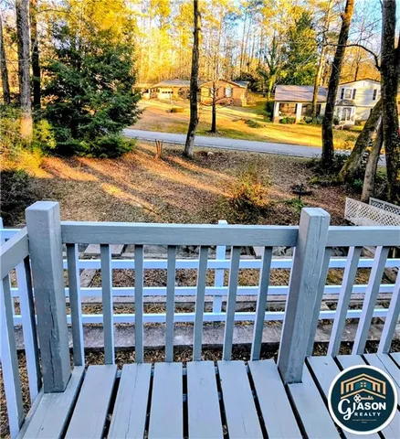 a view of a balcony with wooden floor and fence