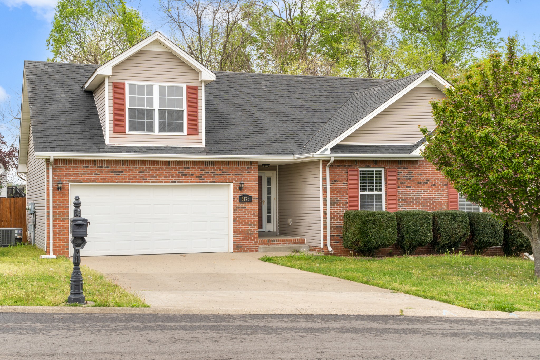 a front view of a house with a garden and plants