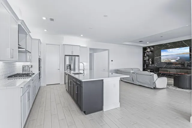 a kitchen with stainless steel appliances kitchen island granite countertop a stove and a sink