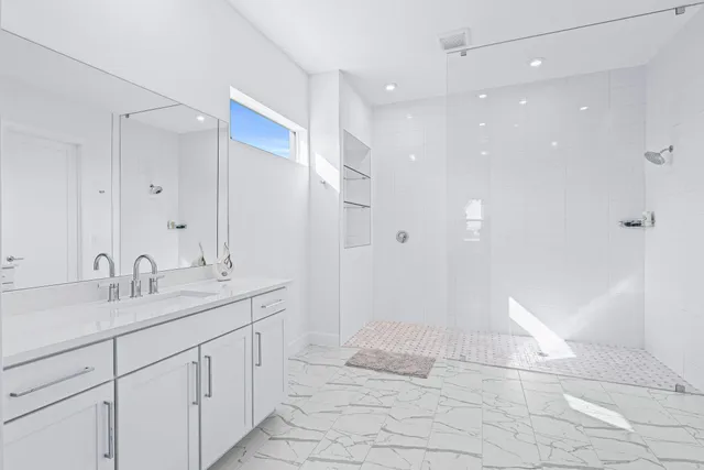 a bathroom with a sink a mirror and a shower