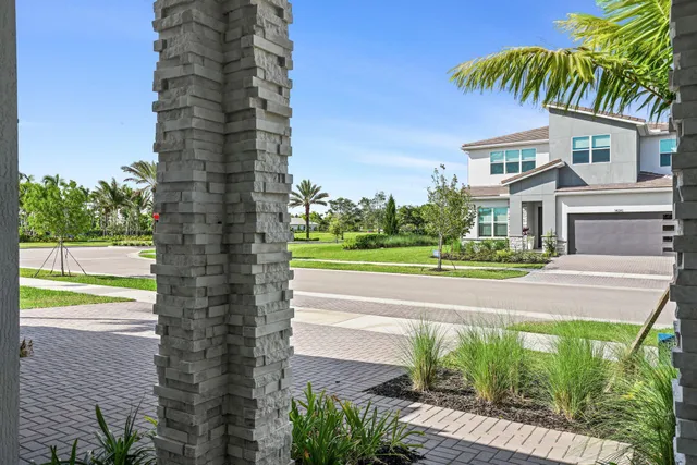 a front view of a house with a yard and potted plants