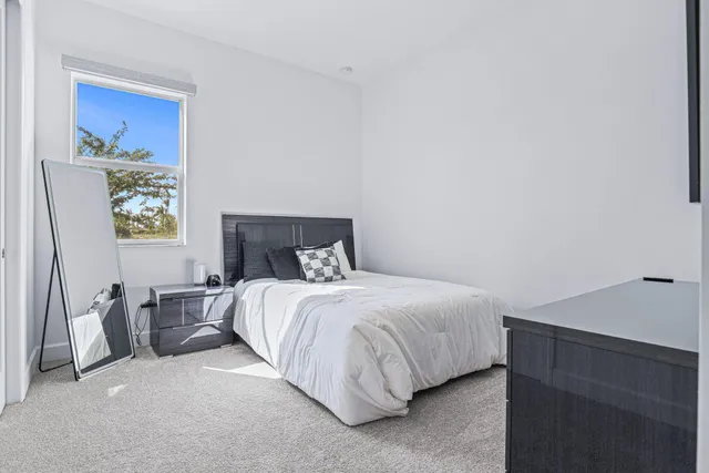 a bedroom with a bed and painting on the wall
