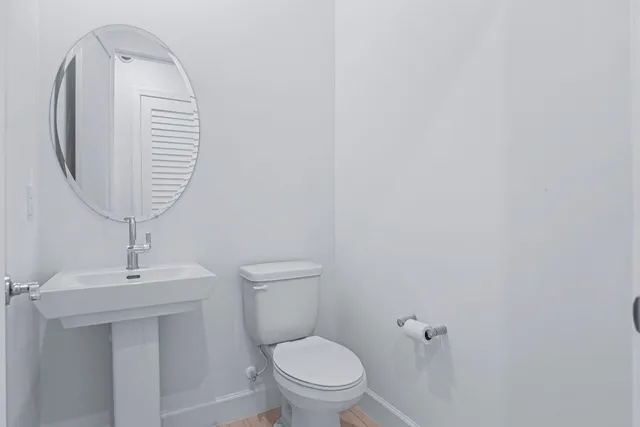 a bathroom with a sink a toilet and a mirror
