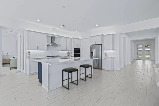 a kitchen with stainless steel appliances granite countertop a refrigerator and a stove top oven