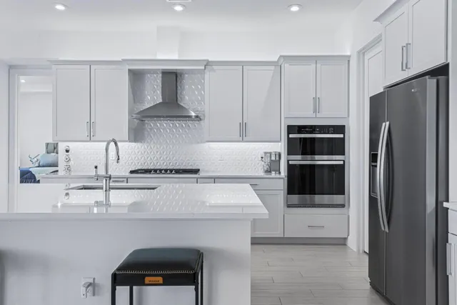 a kitchen with stainless steel appliances granite countertop a refrigerator and a stove top oven