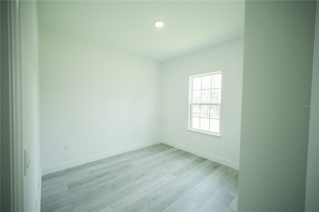 13265 Southwest 85th Circle Ocala, FL 34473 - Photo 21 of 53 an empty room with wooden floor and windows