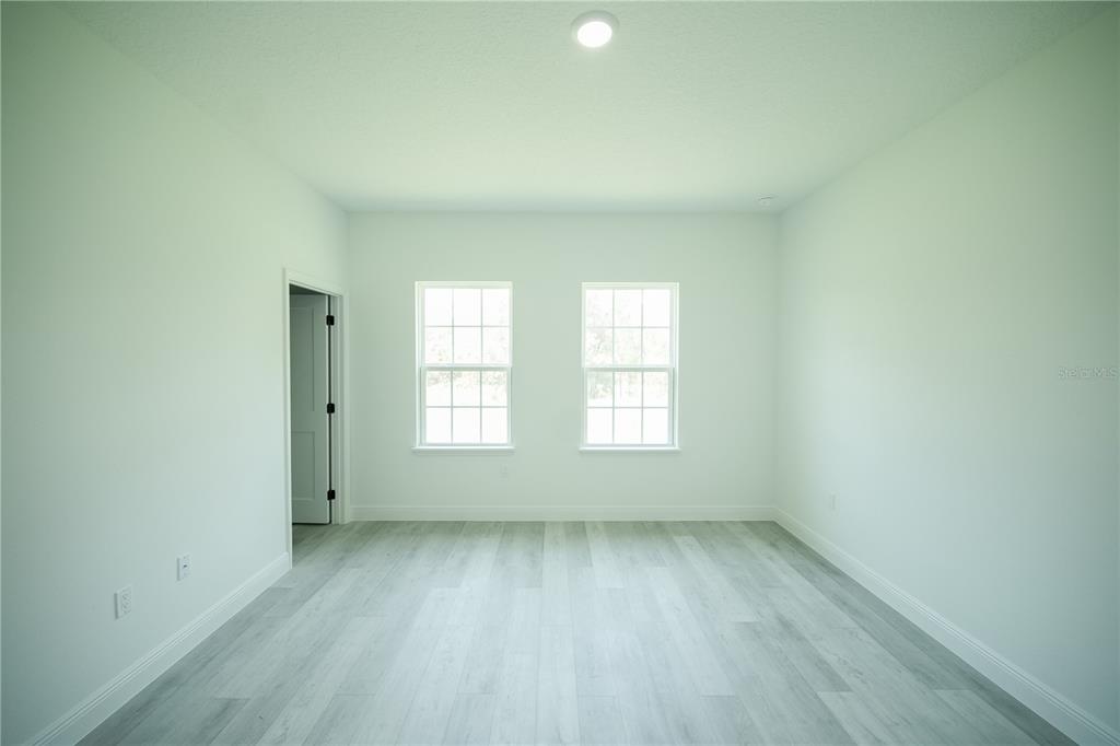 13265 Southwest 85th Circle Ocala, FL 34473 - Photo 38 of 53 an empty room with wooden floor and windows