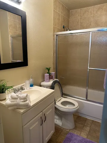 a bathroom with a sink a toilet and shower