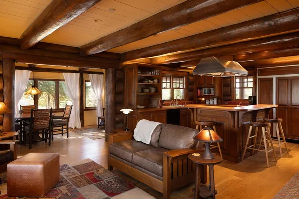 a living room with furniture a wooden floor and kitchen view
