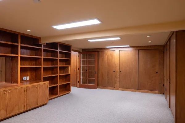 a view of an empty room with a cabinet and a bookshelf