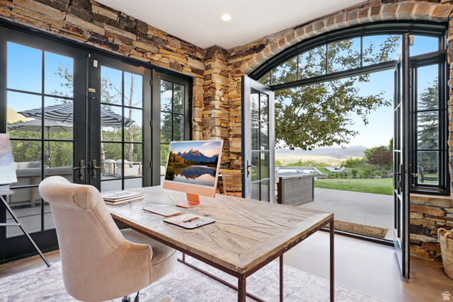 5971 Maple Ridge Trail Oakley, UT 84055 - Photo 18 of 43 Room featuring stone accent walls and two sets of black-framed French doors