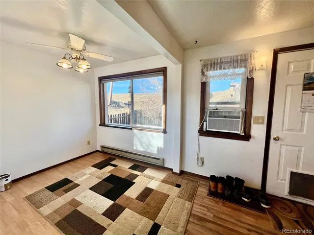 a bedroom with wooden floor and window