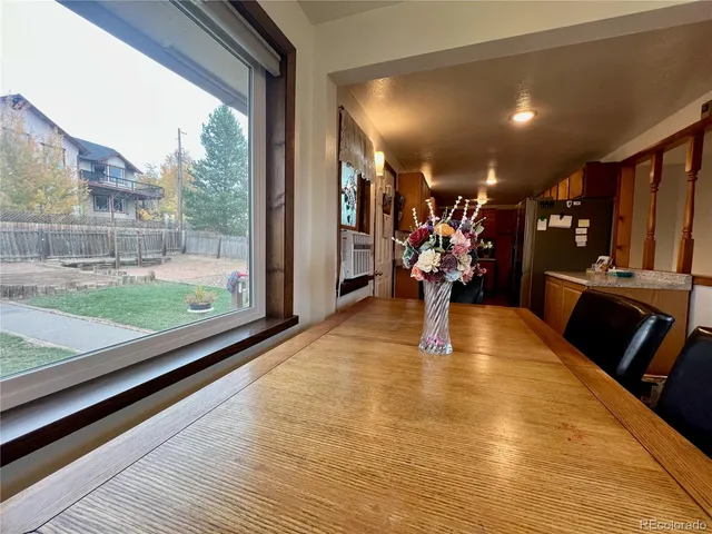 a view of a living room with kitchen floor and a floor to ceiling window