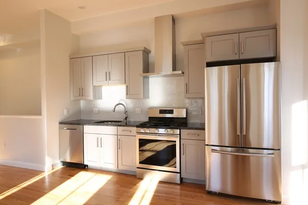 a kitchen with appliances a sink and cabinets