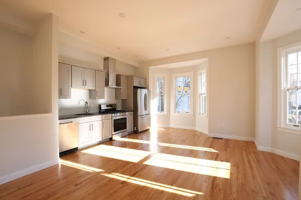 a large kitchen with granite countertop a large counter top space a sink stainless steel appliances and cabinets