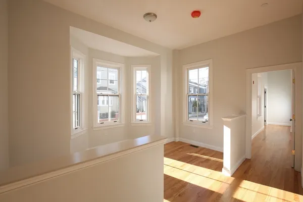 a view of an empty room with glass door and wooden floor