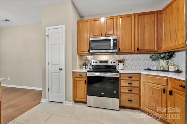 a kitchen with granite countertop a stove top oven microwave and cabinets