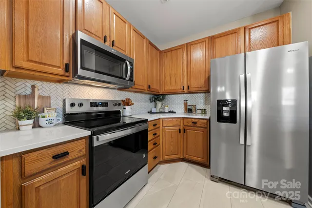 a kitchen with stainless steel appliances granite countertop a refrigerator stove microwave and sink
