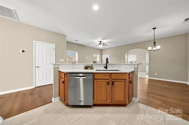 a kitchen with stainless steel appliances granite countertop a sink a stove a refrigerator and white cabinets