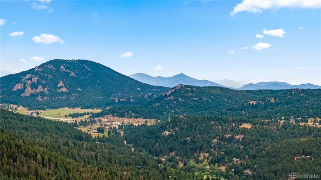 a view of a house with a mountain and a forest