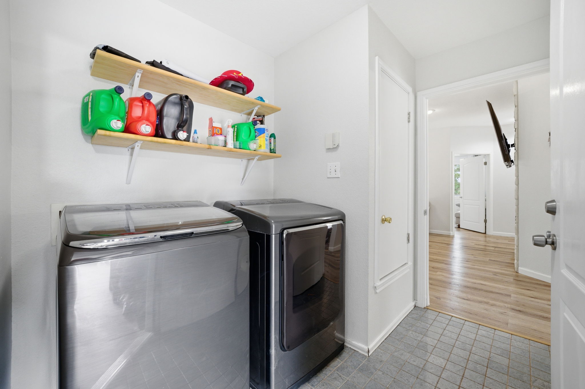 9024 Heiden Lane Austin, TX 78749 - Photo 19 of 28 Dedicated laundry area featuring a tile floor, white walls, and built-in wood shelving for storage