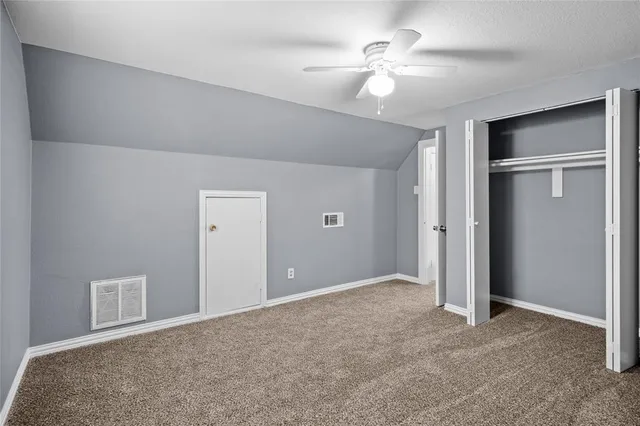 a view of an empty room with a ceiling fan