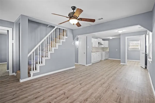 a view of an entryway wooden floor and a kitchen