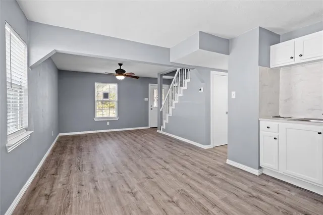 an empty room with windows and cabinet