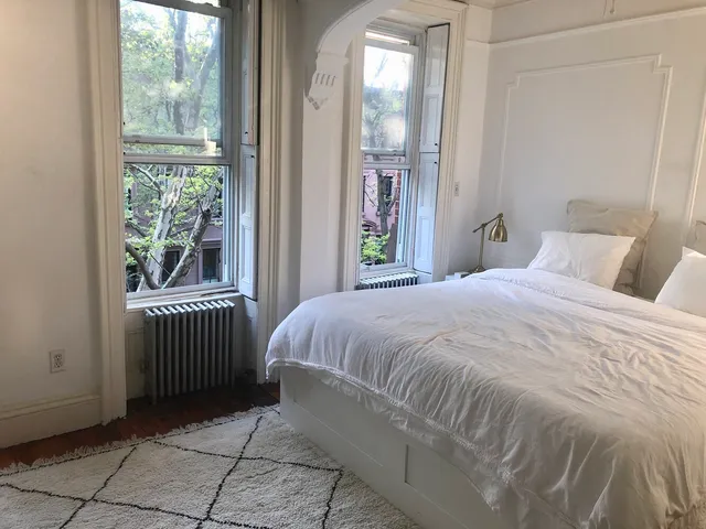 a bedroom with a bed and a window