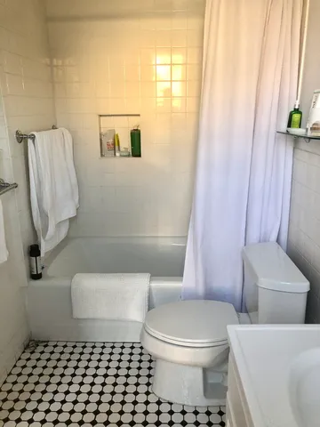a white toilet sitting next to a bathroom sink and tub