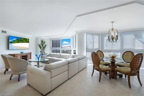 a living room with furniture chandelier and a window