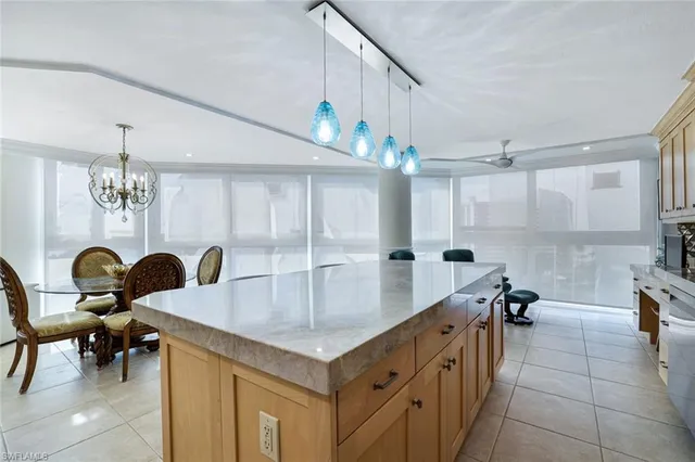 a kitchen with kitchen island granite countertop a sink a counter top space and living room view