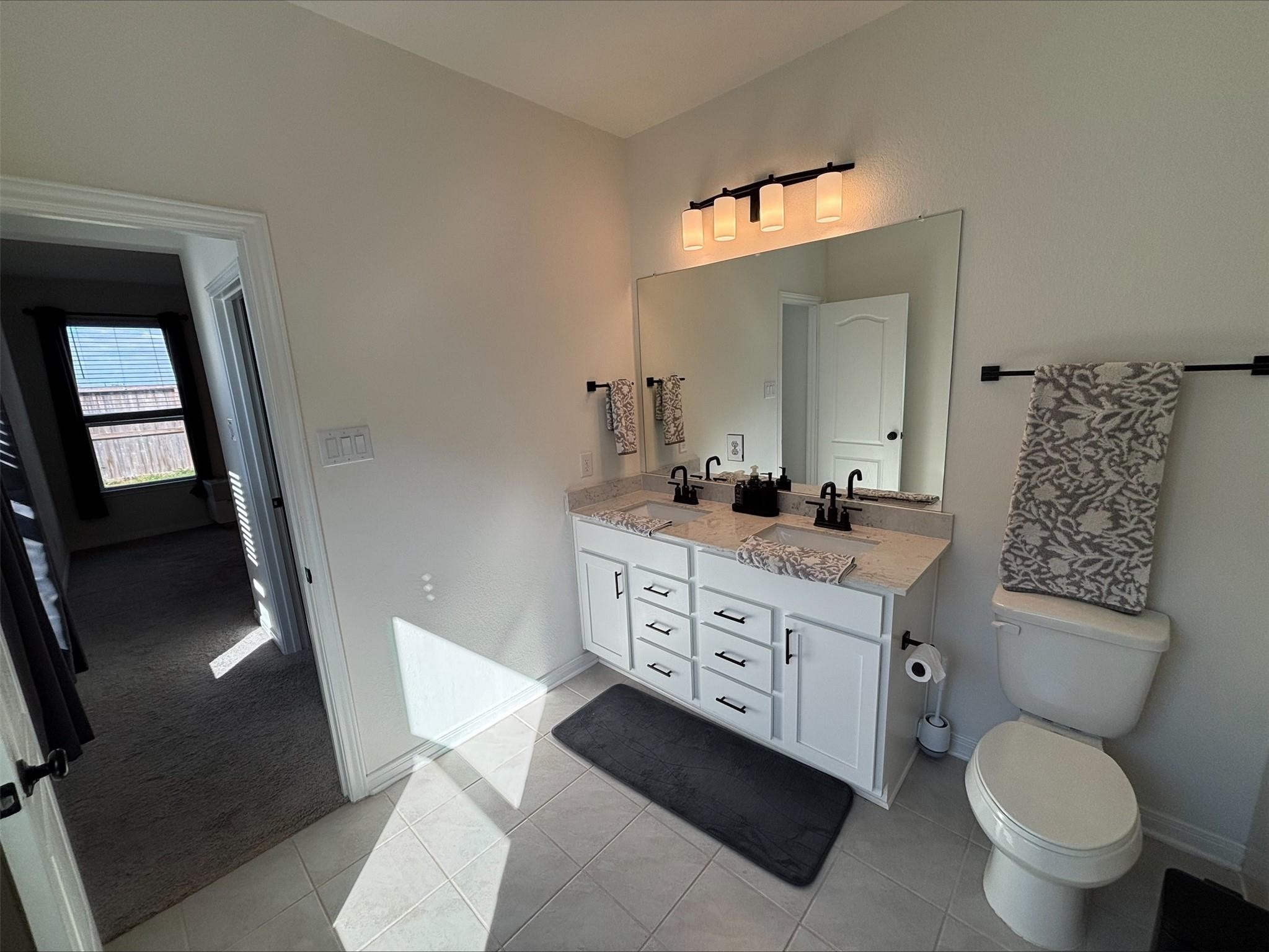 1323 Rosemead Drive Rosharon, TX 77583 - Photo 22 of 27 a bathroom with a granite countertop toilet a sink and a mirror