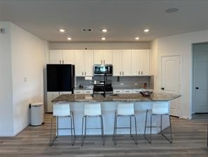 1323 Rosemead Drive Rosharon, TX 77583 - Photo 6 of 27 a kitchen with kitchen island granite countertop a stove a sink a microwave and a refrigerator