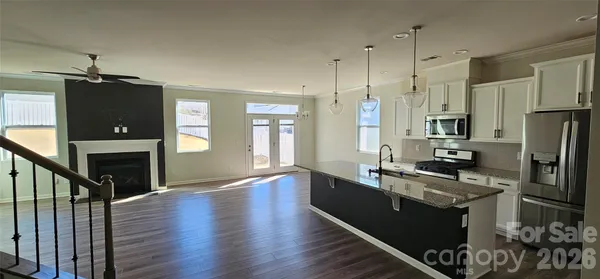 a kitchen with stainless steel appliances granite countertop a refrigerator a stove and a wooden floors
